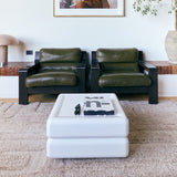 Tufted fluffy beige rug withe a modern white coffee table and retro chairs