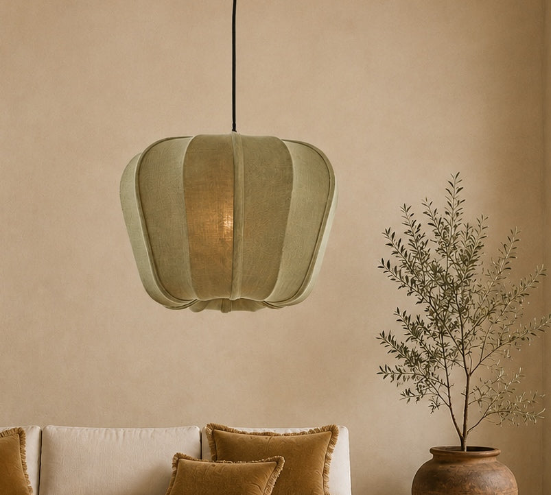 Green pendant light above a beige sofa with brown cushions, against a beige wall.