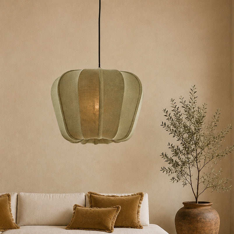 Green pendant light above a beige sofa with brown cushions, against a beige wall.