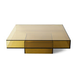 A modern square coffee table with a translucent amber-tinted glass top and matching glass base, shown on a clean white background.