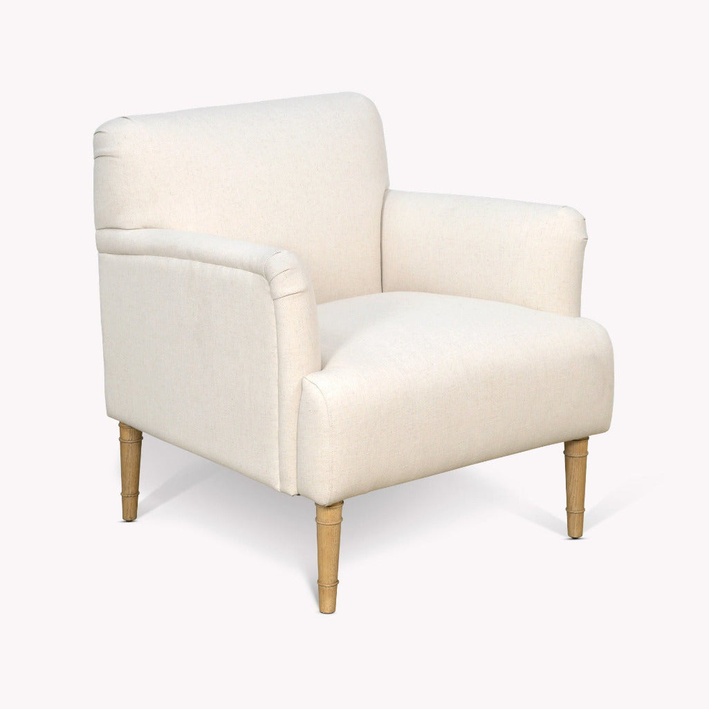 An upholstered armchair with cream fabric and tapered light wood legs, shown on a plain light gray background.