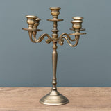 Bronze candelabra on a wooden surface with a gray background