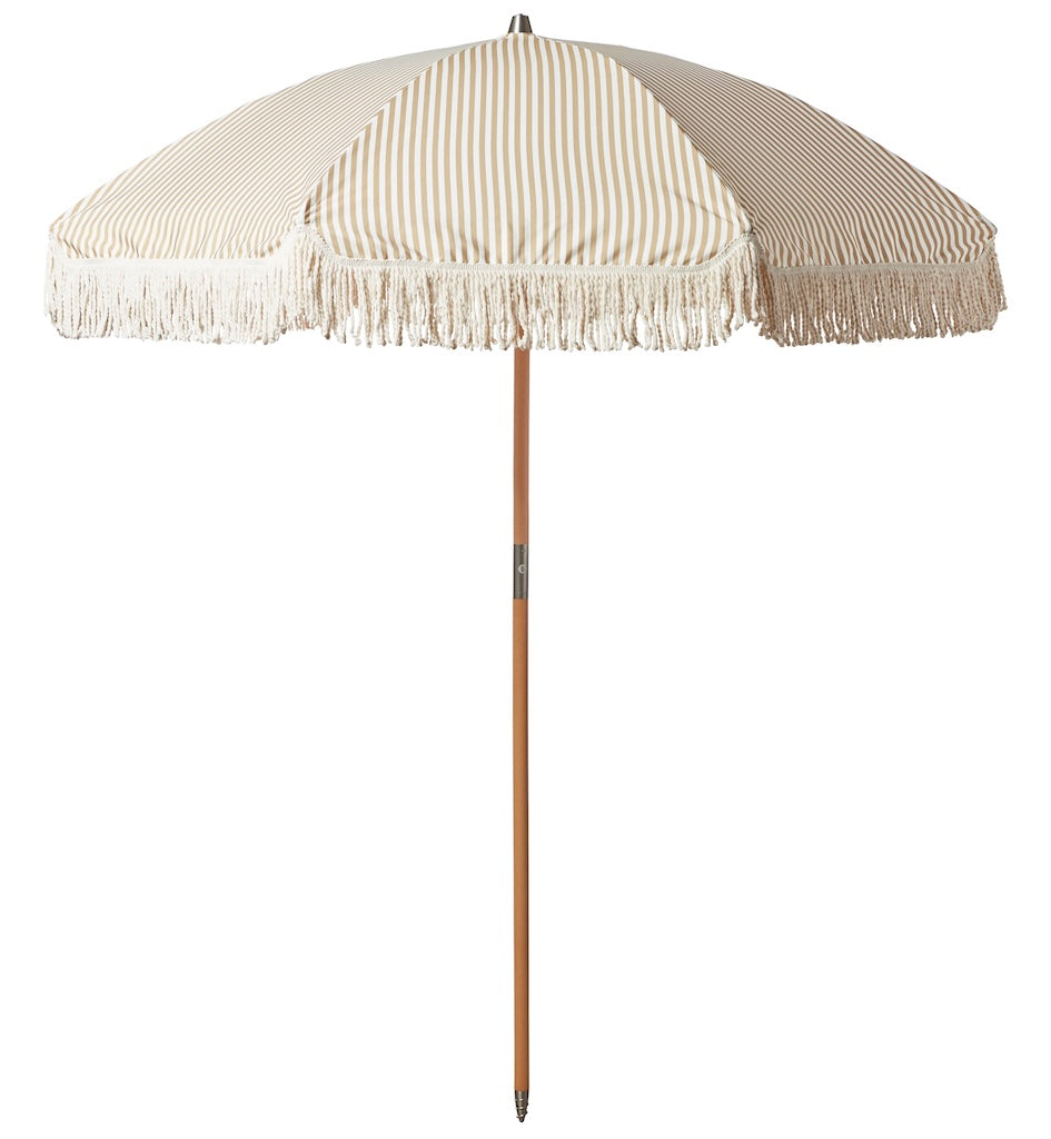 Beige striped beach umbrella with tassels on a white background