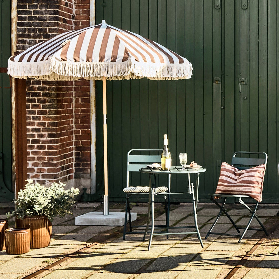 bistro table and chairs and striped umbrella