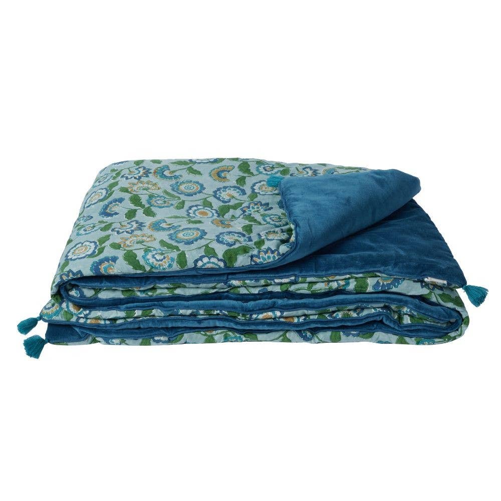 Folded blue floral blanket on a white background
