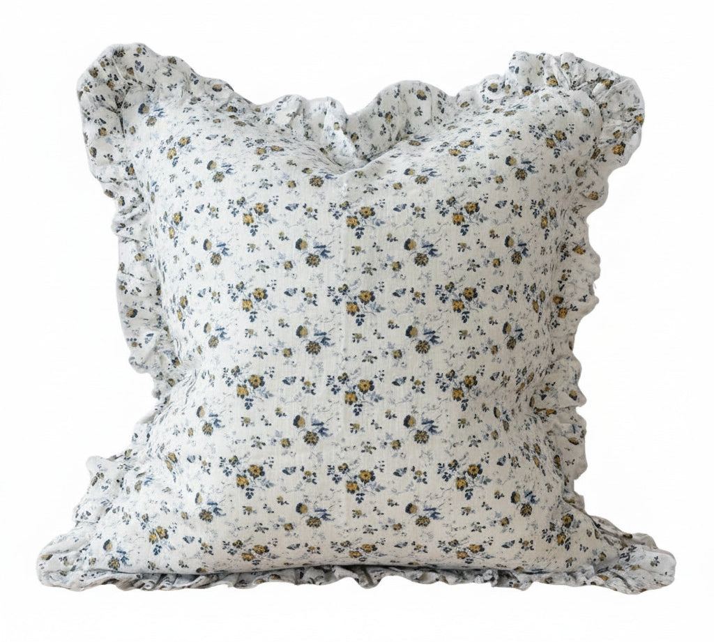 Floral patterned pillow with ruffled edges on a white background