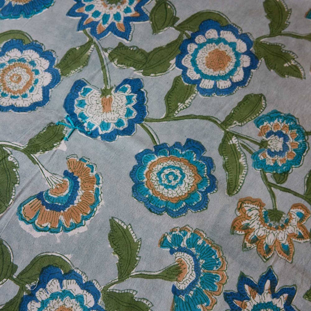 Floral sofa throw with blue, green, and orange flowers on a gray background