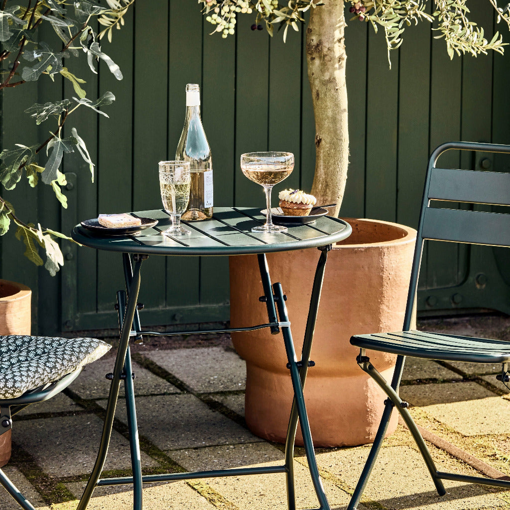 Outdoor setting with a small table, chairs, and drinks on a patio.