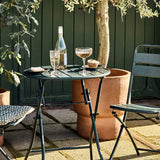Outdoor setting with a small table, chairs, and drinks on a patio.