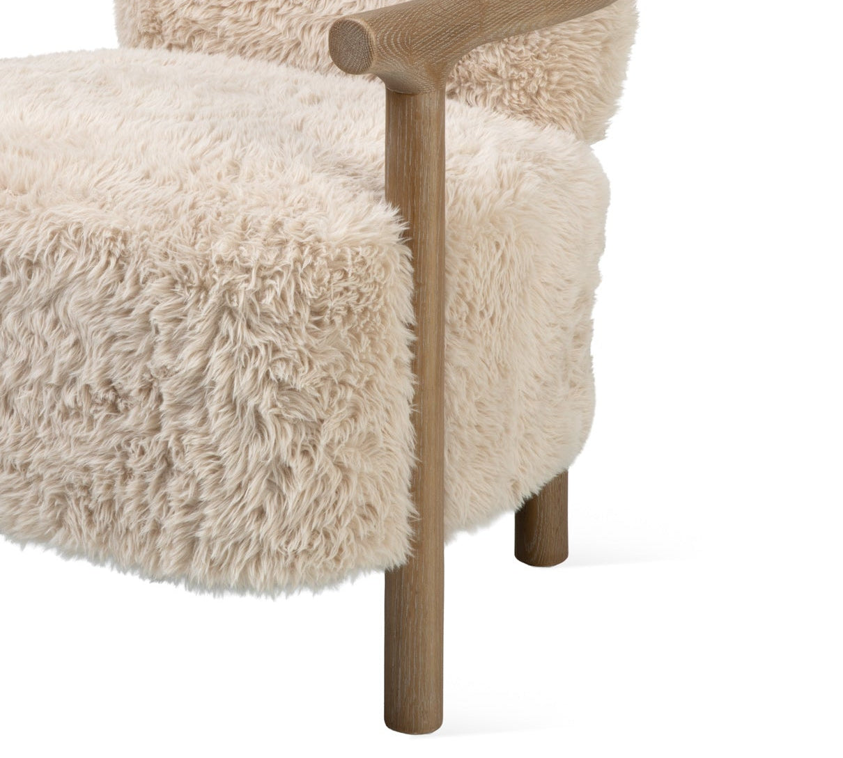 A modern accent chair featuring a thick, shaggy cream-colored sheepskin or faux fur upholstery with a natural light brown wooden frame and curved armrests, shown against a solid white background.