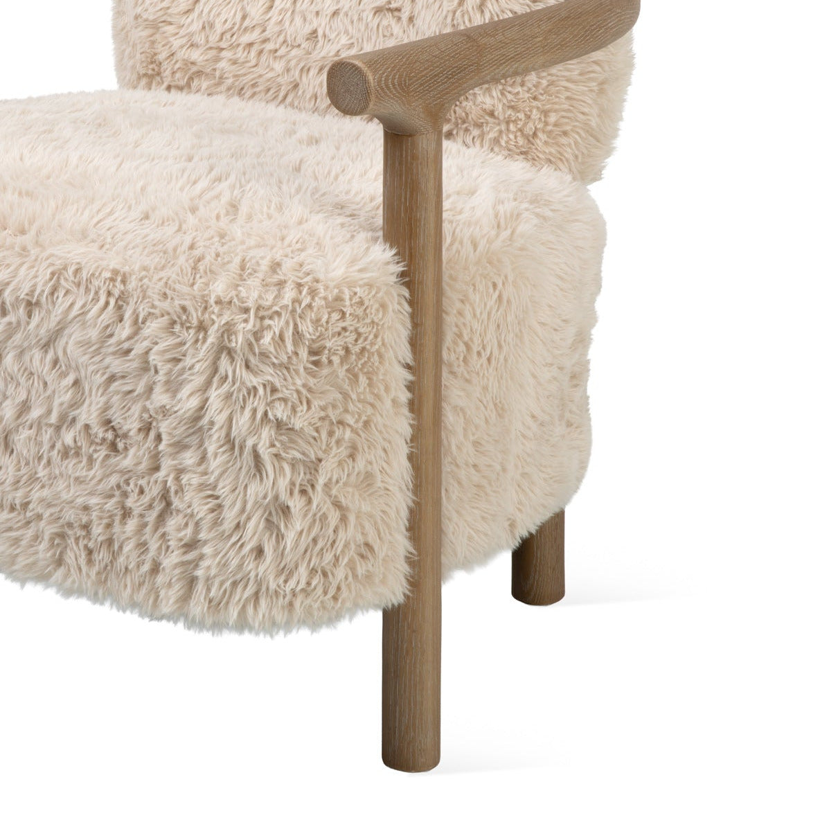 A modern accent chair featuring a thick, shaggy cream-colored sheepskin or faux fur upholstery with a natural light brown wooden frame and curved armrests, shown against a solid white background.