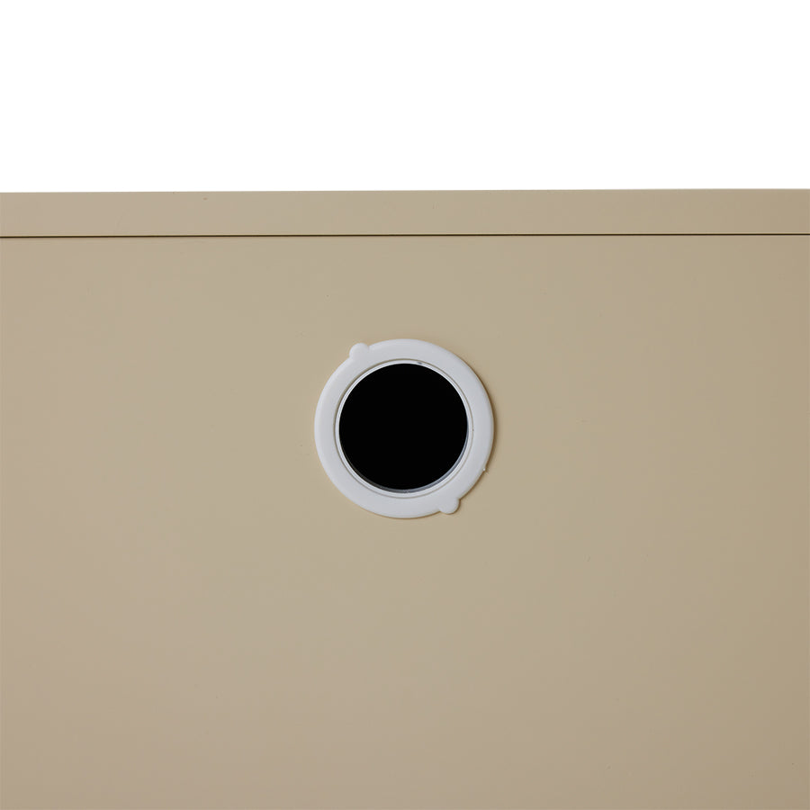 Beige cabinet with a circular black hole on a white background