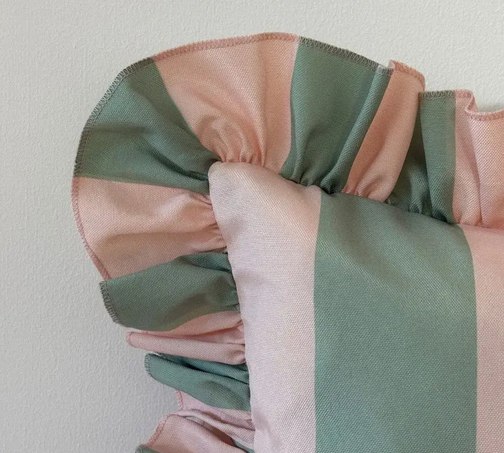Close-up of a pink and green striped fabric with a plain background