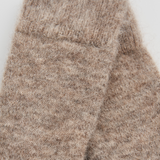 Close-up of a pair of heathered knit socks in a warm taupe-brown color, showing the soft texture and ribbed cuff detail against a light background.