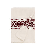 An off-white cotton muslin tea towel with a dark burgundy embroidered floral pattern, folded neatly on a solid white background.
