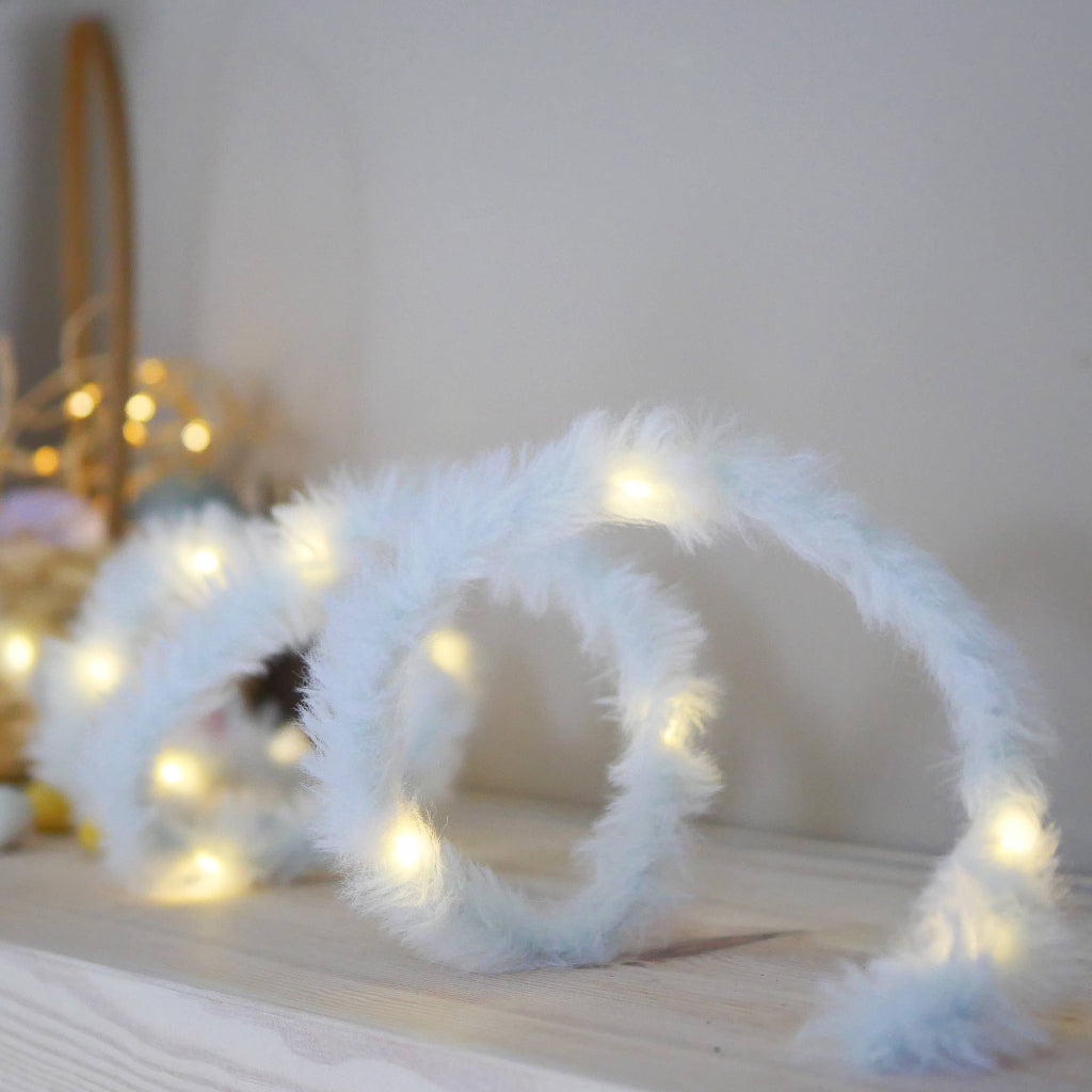 White fluffy string lights on a wooden surface