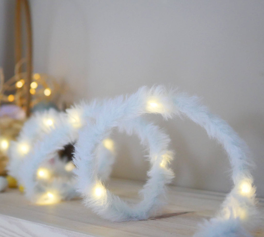 White fluffy string lights on a wooden surface