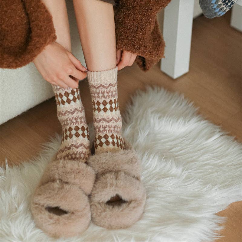 Person wearing patterned socks and fuzzy slippers on a fluffy rug