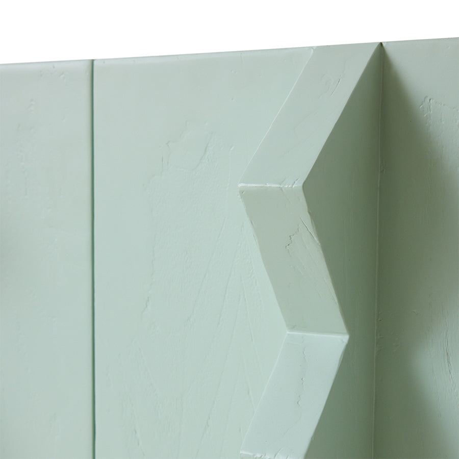 Close-up of a light green wall with geometric design