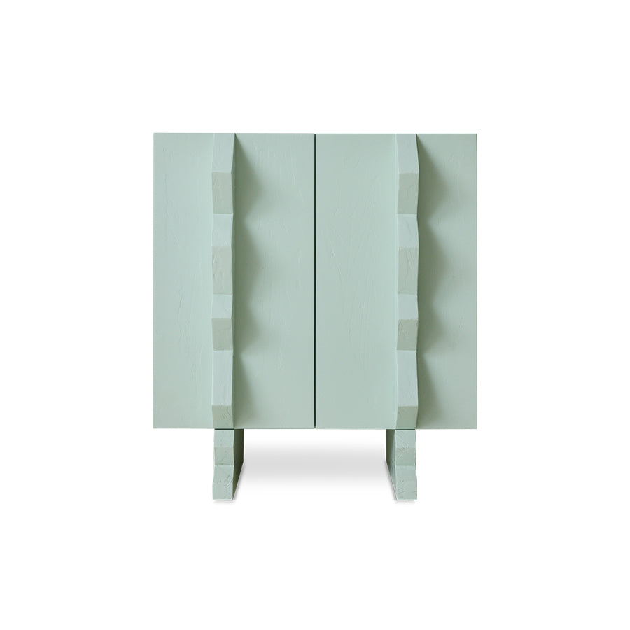 A modern two-door cabinet in a pale blue finish, featuring sculptural, stepped geometric handles and matching feet, shown against a plain white background.