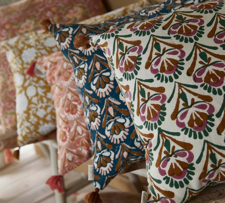 Decorative pillows with floral patterns on a wooden surface