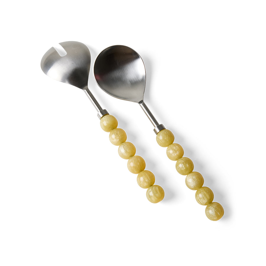 Two stainless steel serving utensils with pale yellow beaded handles, shown on a clean white background.