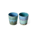 Two ceramic cups with blue and green patterns on a white background