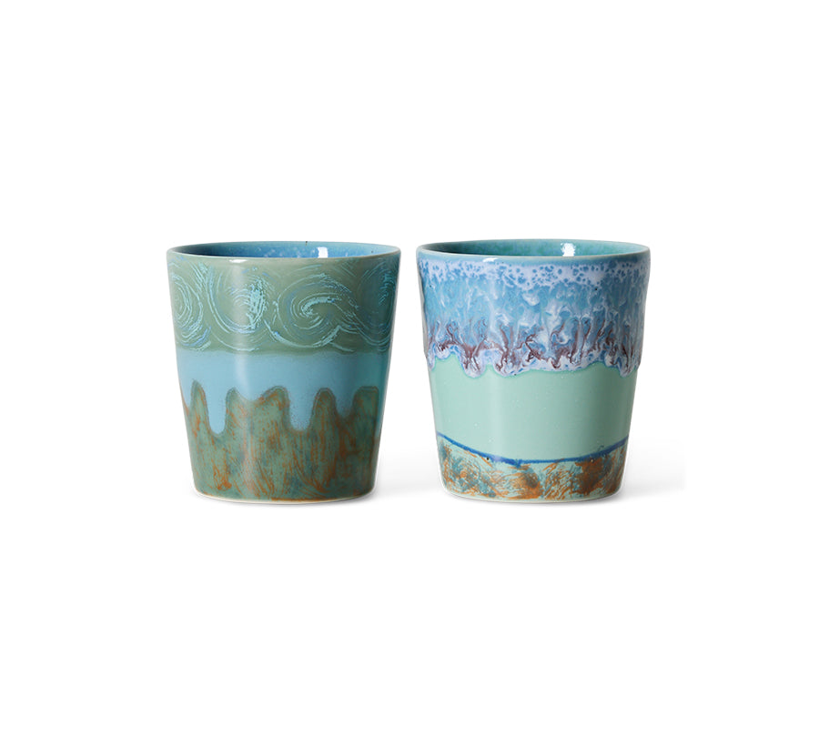 Two ceramic cups with decorative patterns on a white background