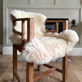 Wooden chair with white fur cover in a room setting