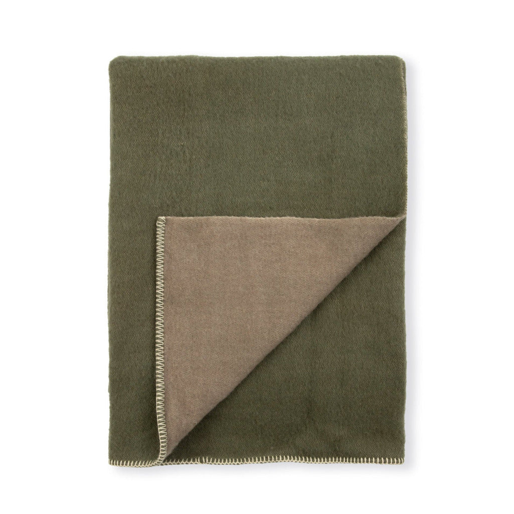 An olive green blanket with a folded corner revealing a taupe-brown reverse side, finished with a fringed edge, shown on a plain white background.