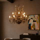 Chandelier hanging above a table with a painting on the wall in a dimly lit room.