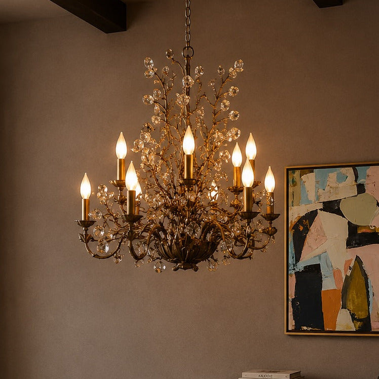 Chandelier hanging above a table with a painting on the wall in a dimly lit room.