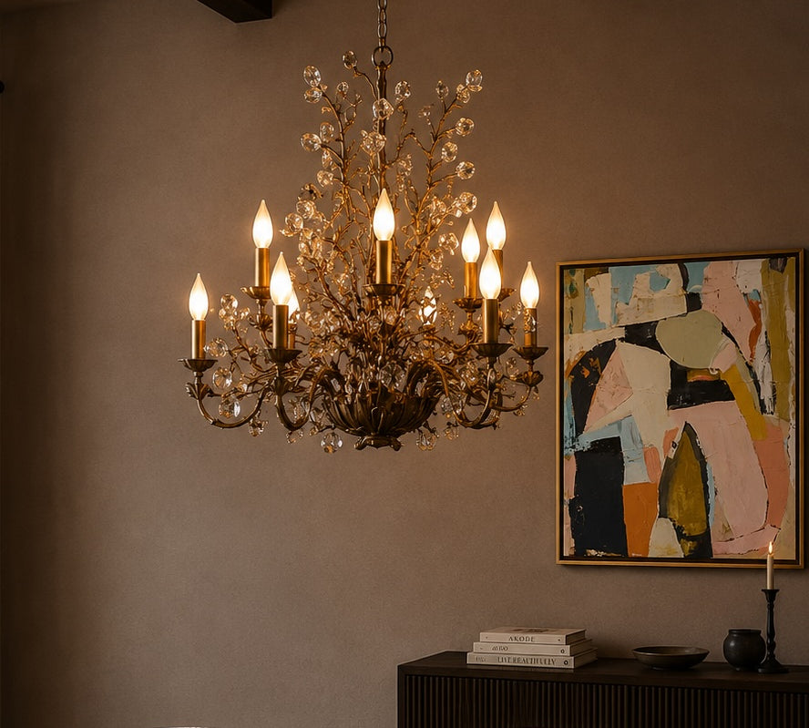Chandelier hanging above a table with a painting on the wall in a dimly lit room.