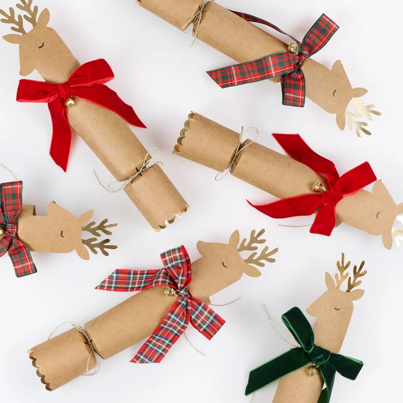 Decorative cracker shaped like reindeer with colorful bows on a white background