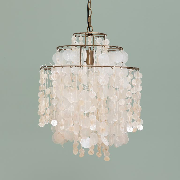 Chandelier with shell-like beads on a plain background