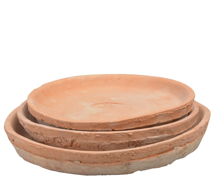 Set of three terracotta saucers stacked on a white background