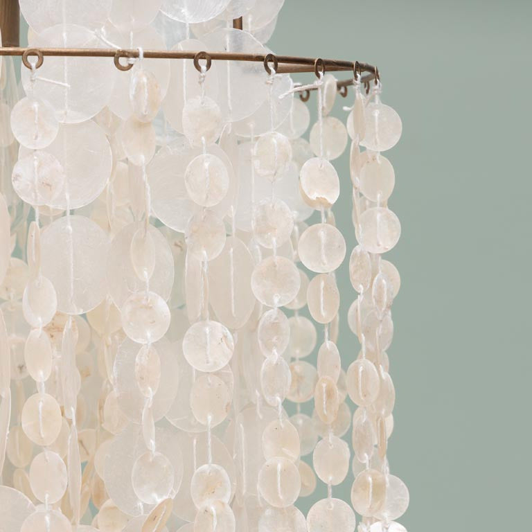 Chandelier with white circular beads on a light gray background