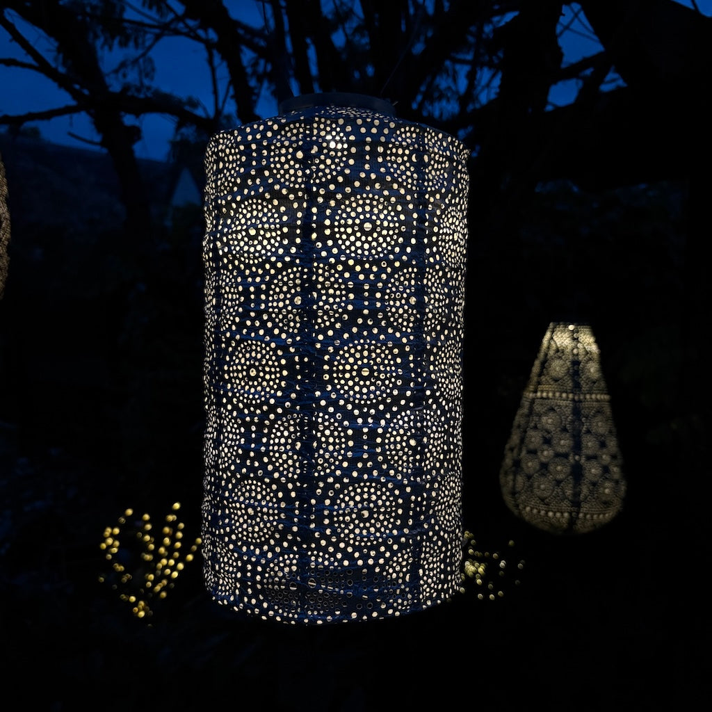 Decorative outdoor lanterns with intricate patterns glowing in the dark.
