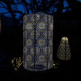 Decorative outdoor lanterns with intricate patterns glowing in the dark.
