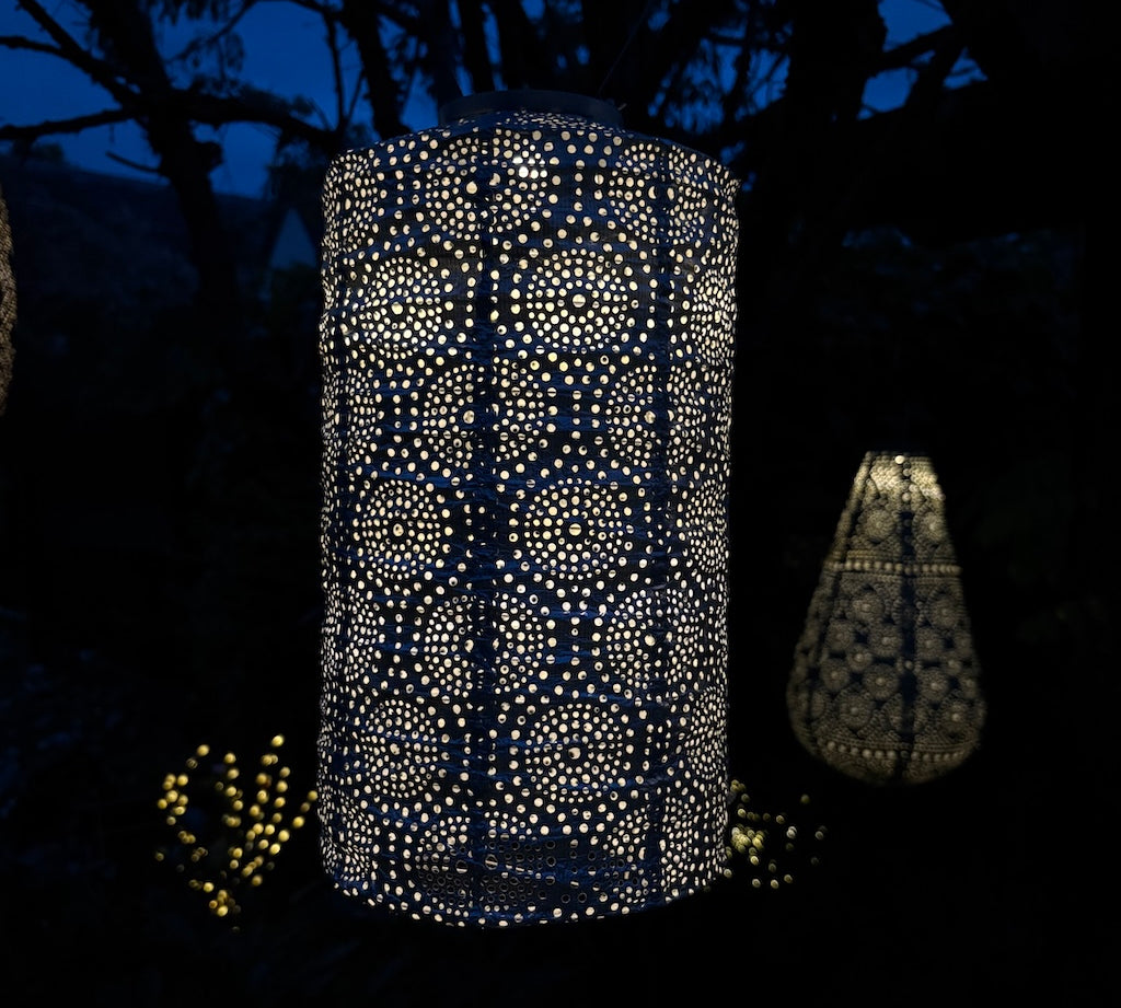 Decorative outdoor lanterns with intricate patterns glowing in the dark.