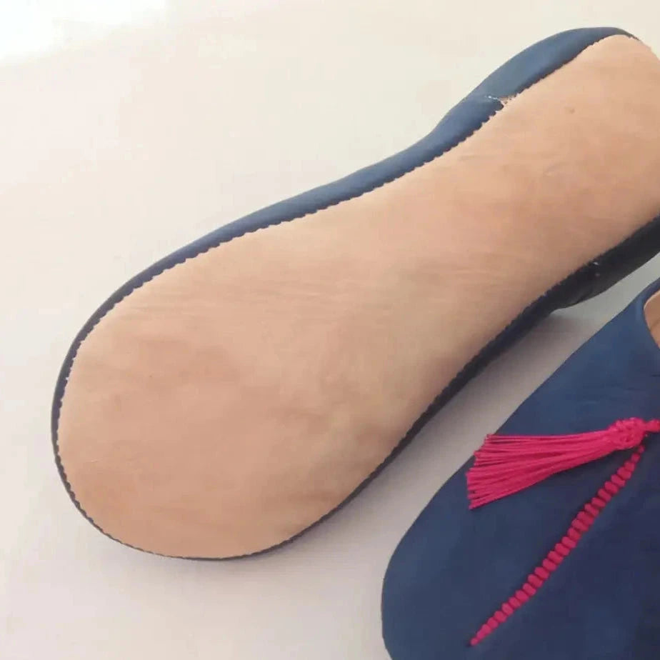 Blue slipper with a pink tassel on a light background