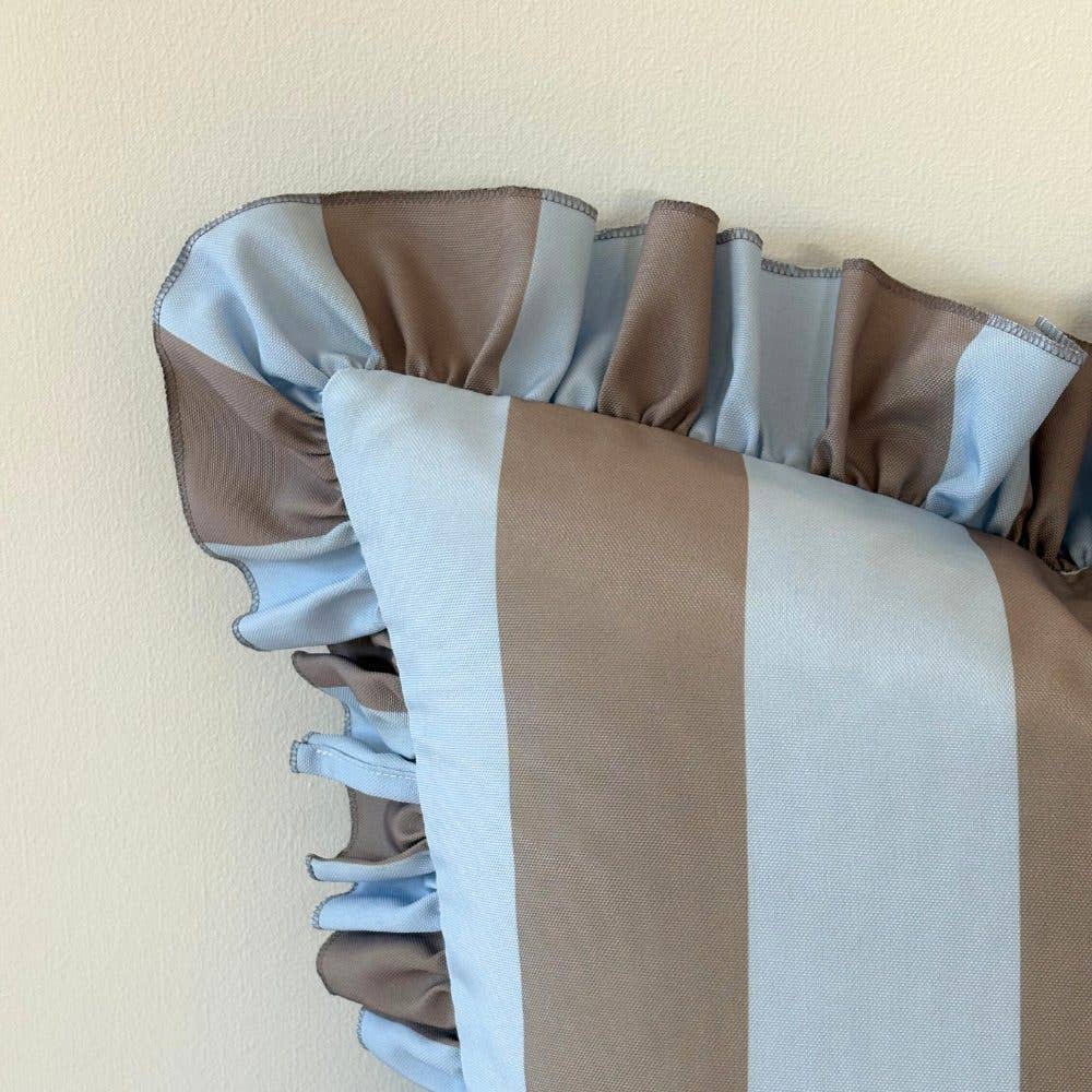 Striped cushion with brown, white, and gray pattern on a beige background