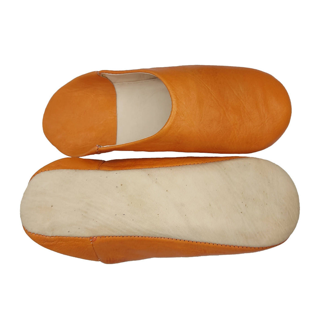 A pair of traditional slip-on mule shoes in tan  leather, showing the side profile of one shoe and the sole of the other against a plain white background.