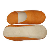 A pair of traditional slip-on mule shoes in tan  leather, showing the side profile of one shoe and the sole of the other against a plain white background.