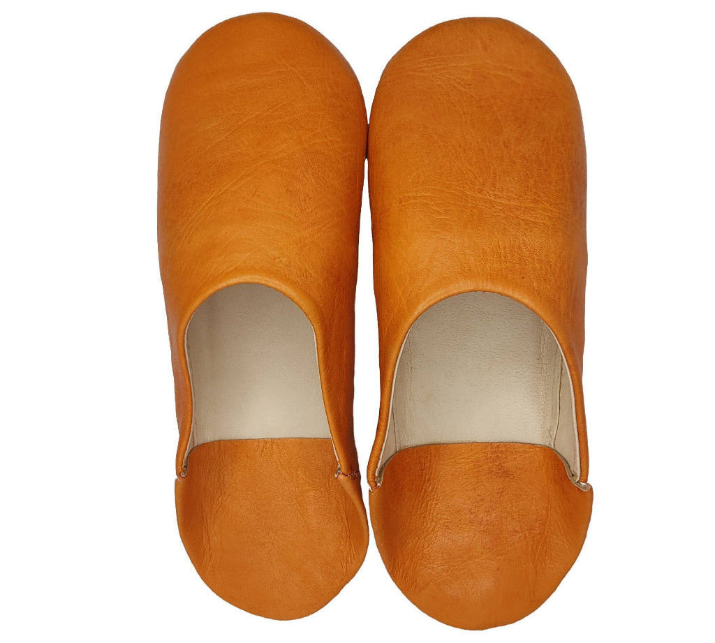 A pair of tan leather mule shoes shown from a top-down view on a solid white background.