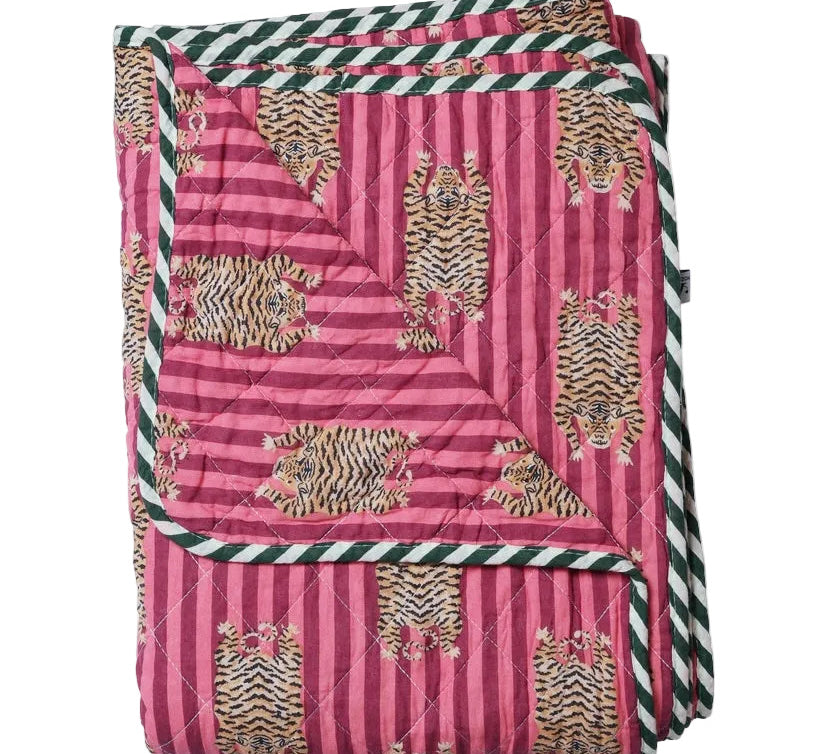 Pink quilt with tiger pattern and green and white striped border on a white background