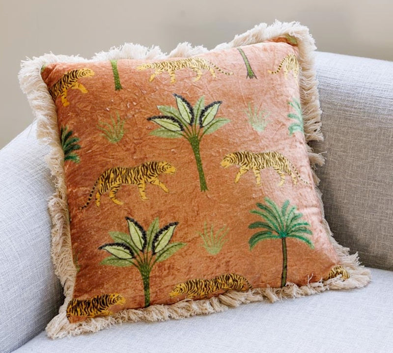 Decorative pillow with tiger and palm tree pattern on a couch