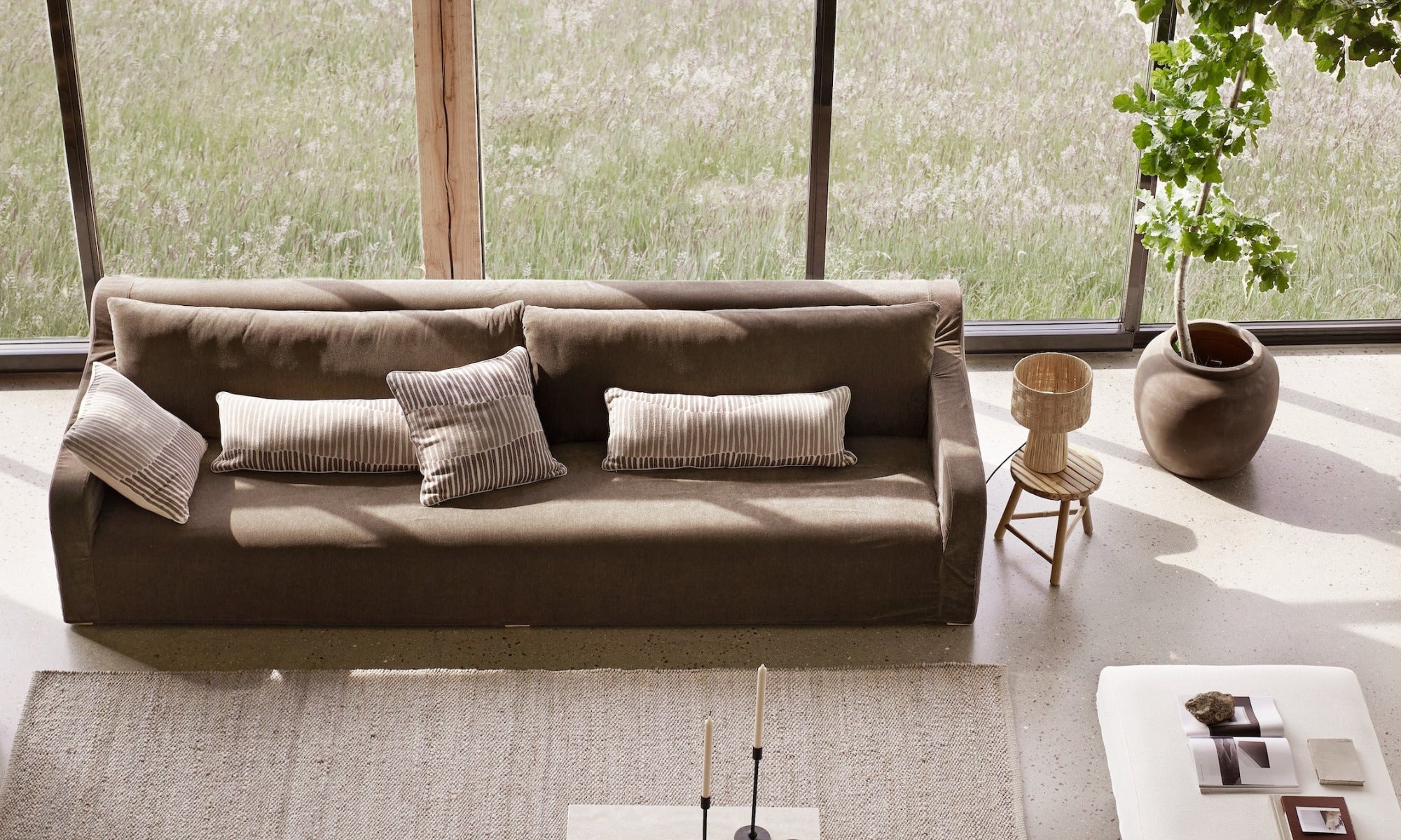 Modern living room with a brown sofa, coffee table, and decorative items.
