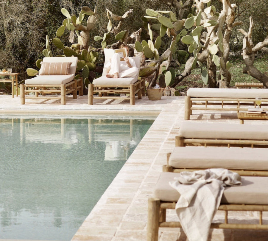 Collection of bamboo loungers by a simming pool