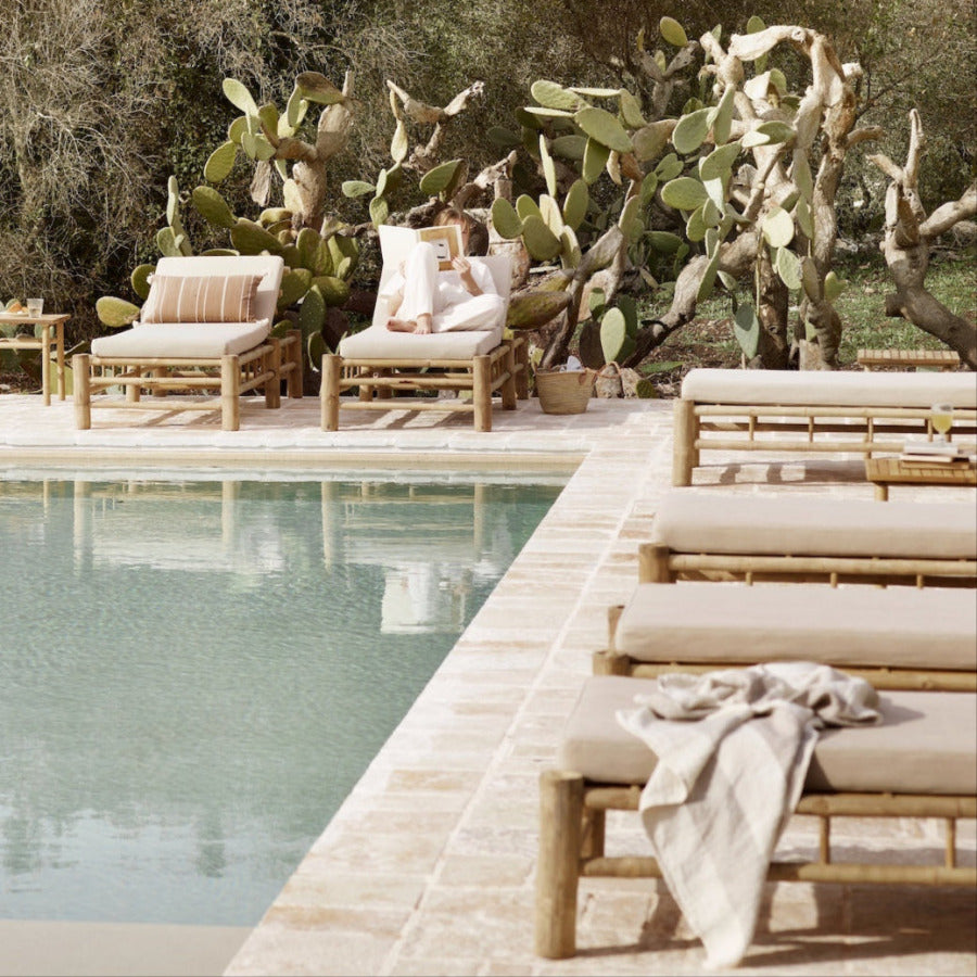 Collection of bamboo loungers by a simming pool
